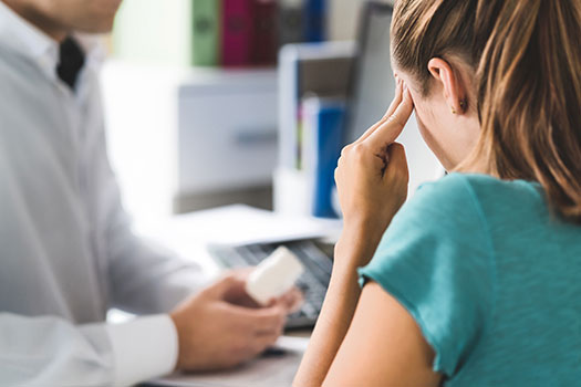 Jeune femme atteinte de migraine dans le bureau du médecin
